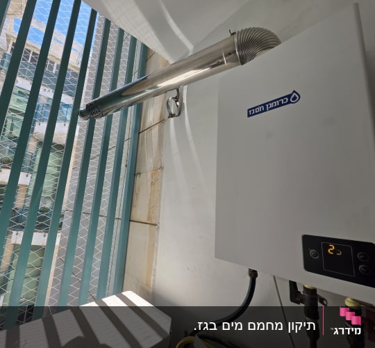 דוד חימום גז מותקן ליד חלון עם סורגים